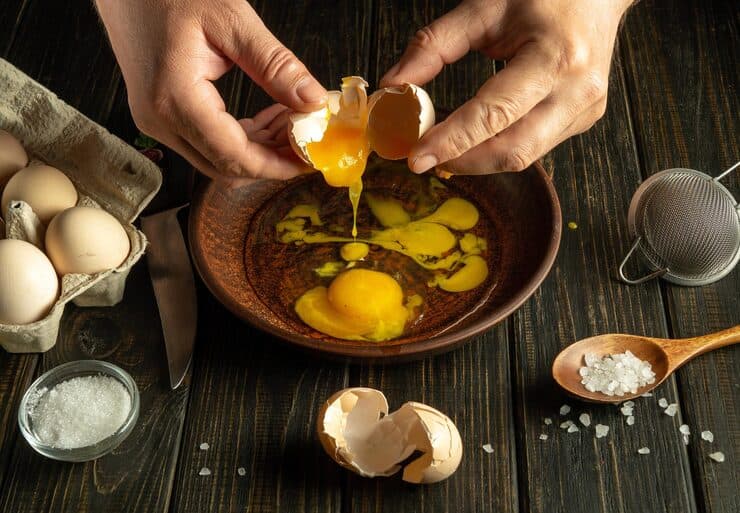 chef breaks egg kitchen table omelet cook ha — guides guide photo