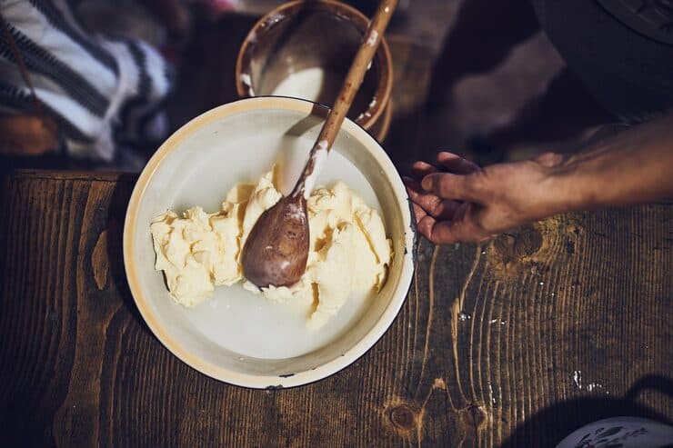 female making butter with butter churn old t — how to make desi ghee from malai article image